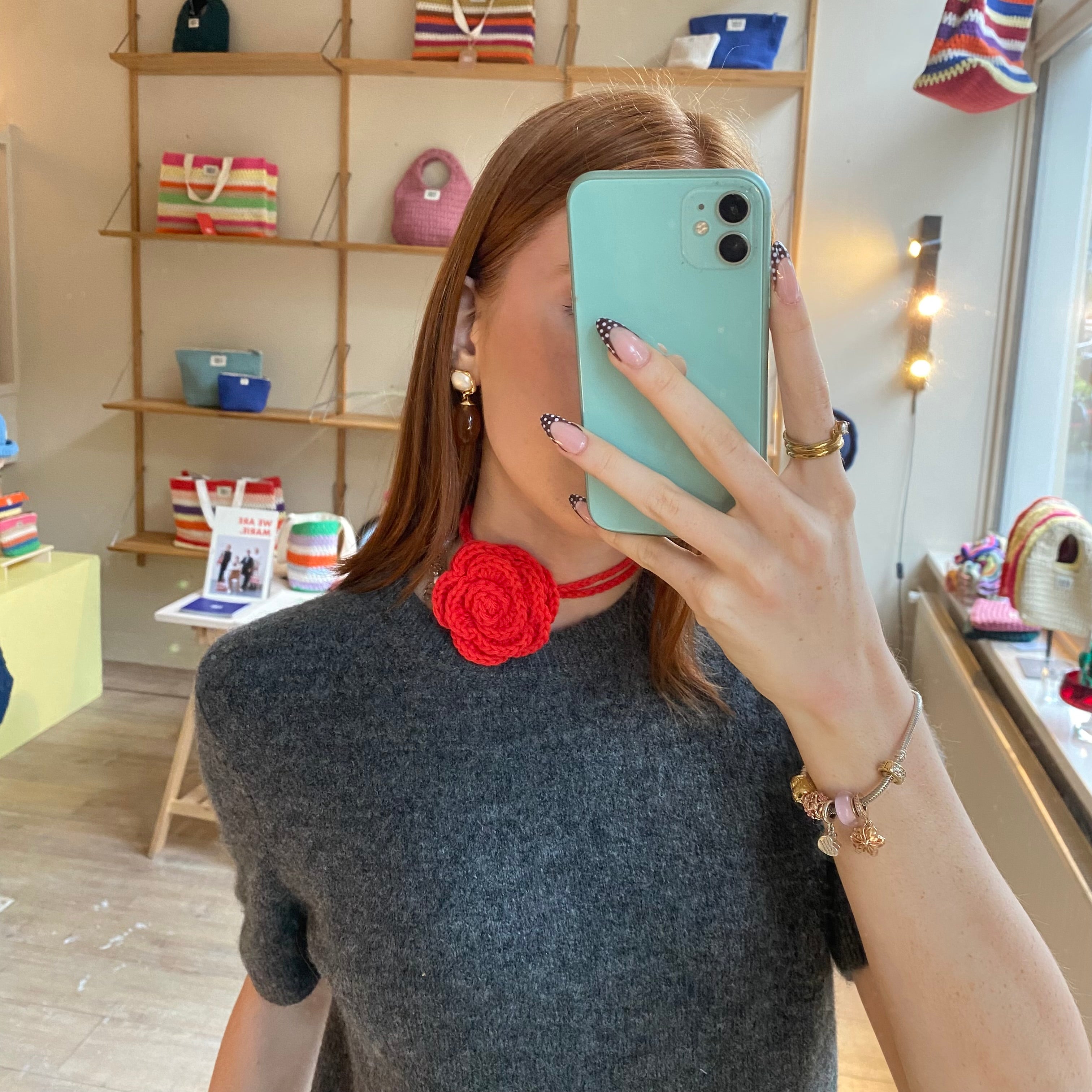 Red crochet corsage detail — bold handmade floral accessory MARIE MARIE